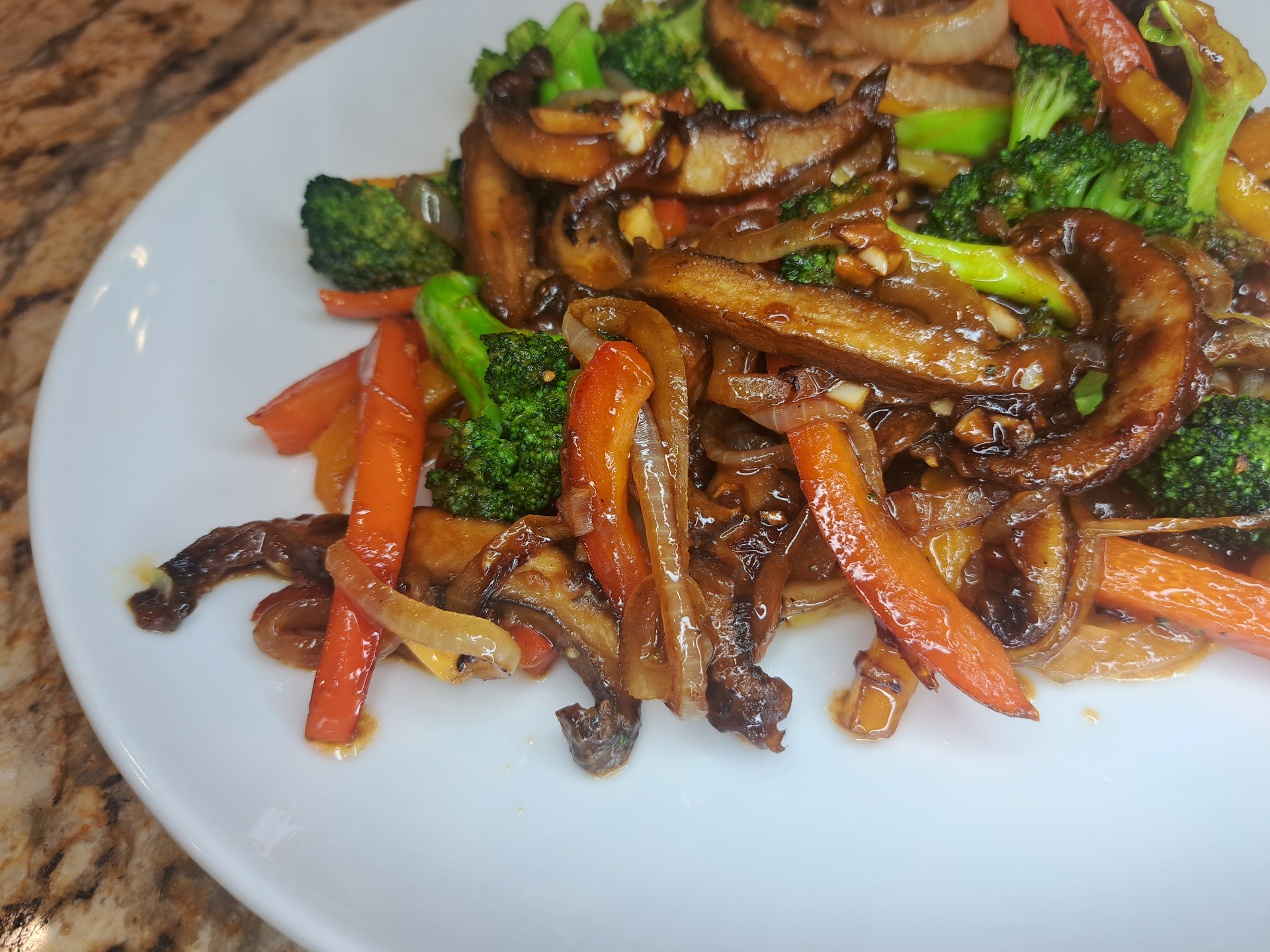 Glossy stir fry with broccoli, carrots, mushrooms and peppers